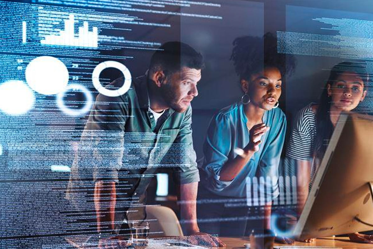 three coworkers looking at charts on screen