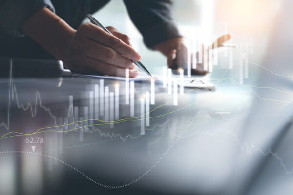 Man writing with tech charts floating above