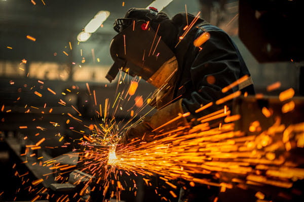 A welder working in safety gear with sparks flying.