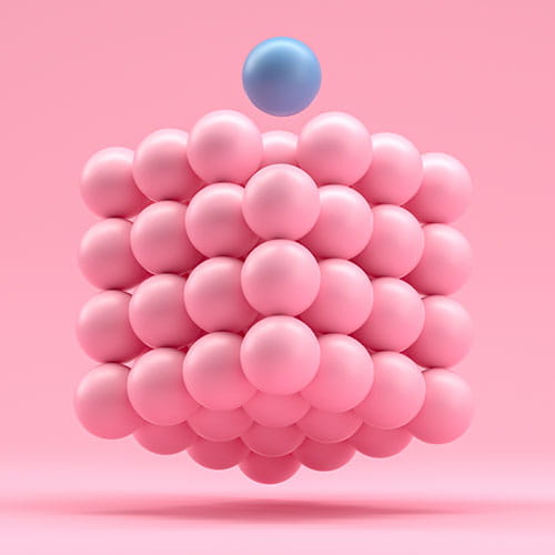 Cube made of tiny pink spheres and one blue sphere.