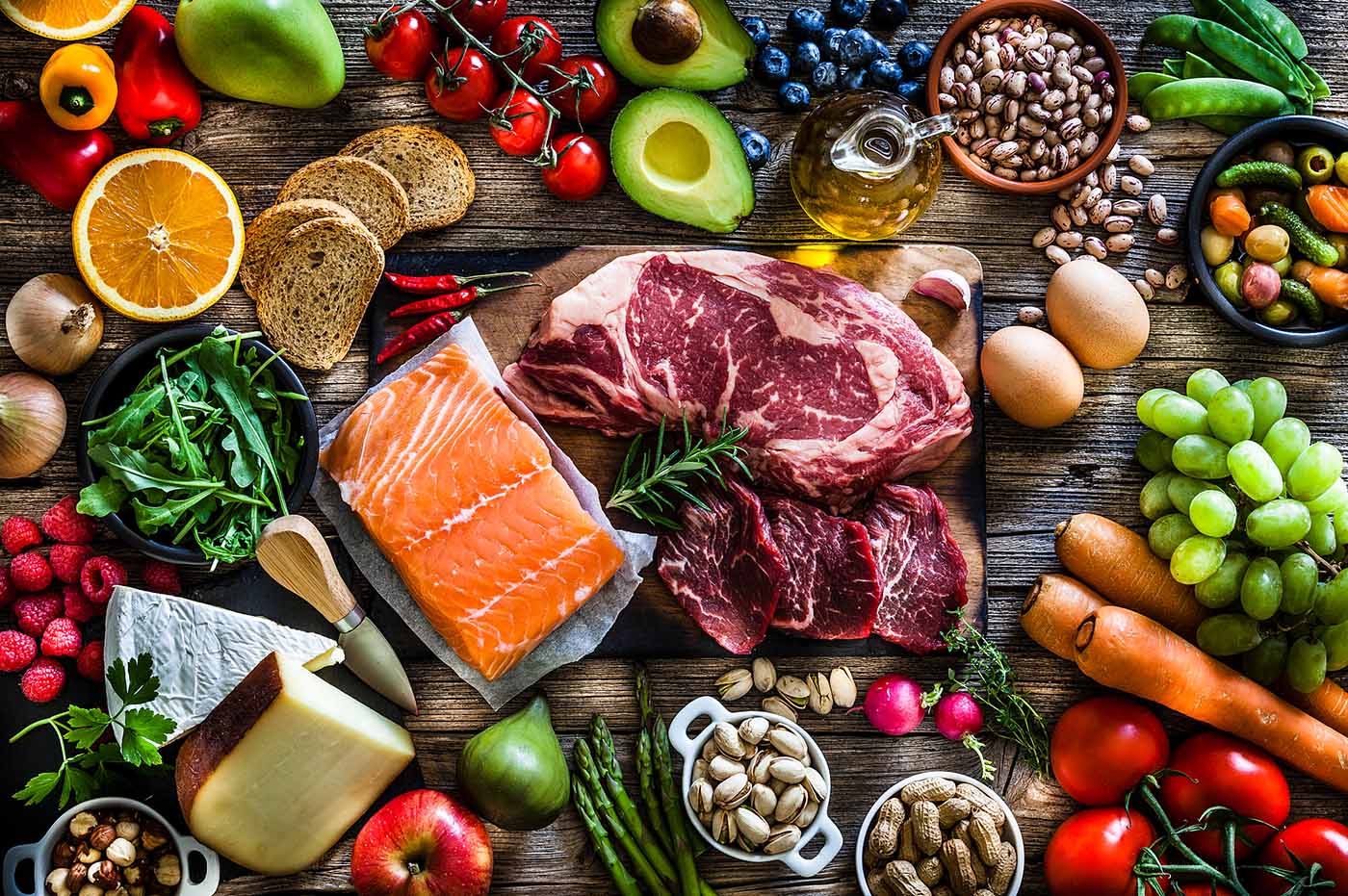 Colorful display of groceries, fruits, vegetables, meats, and cheeses.