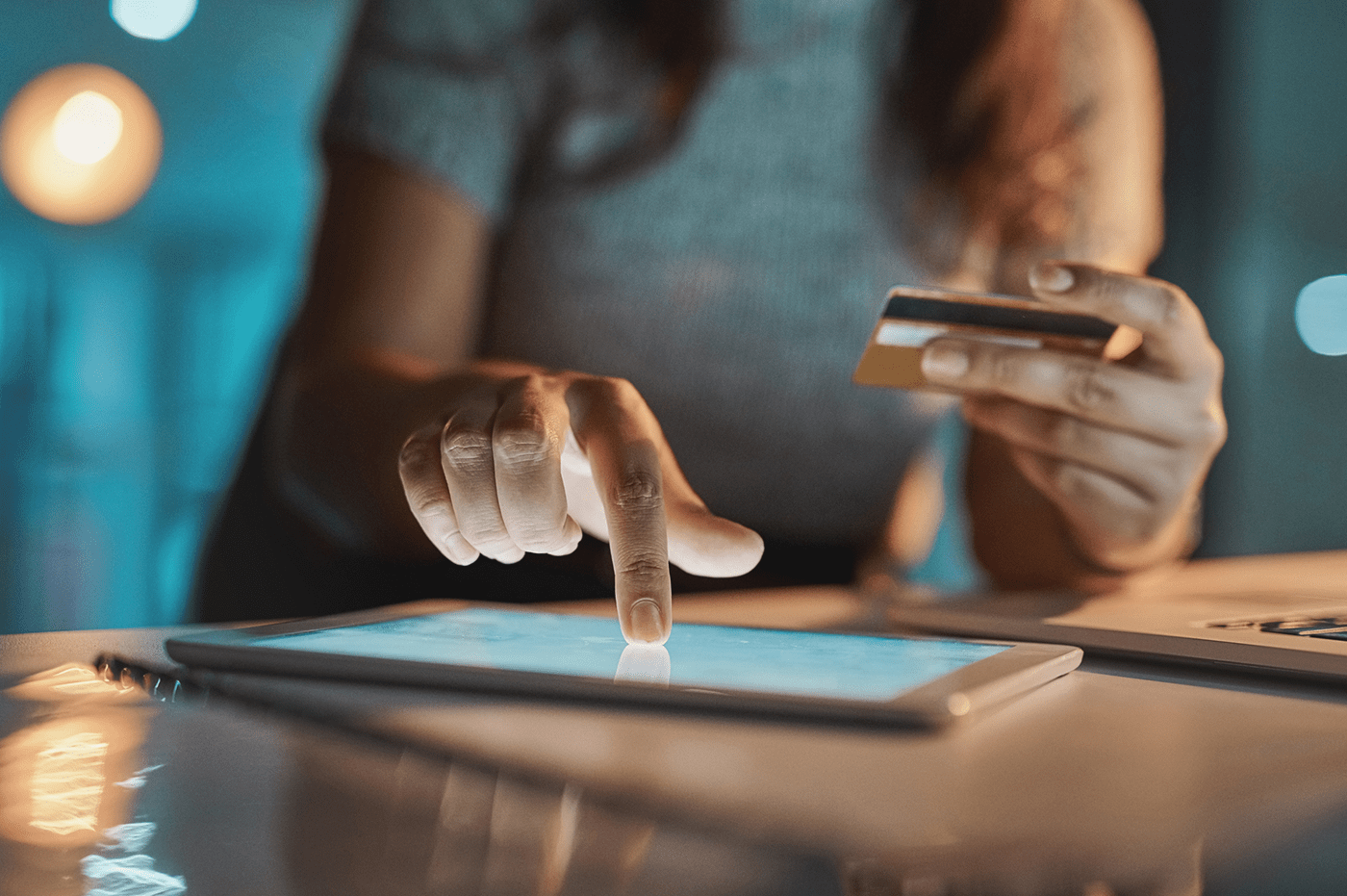 A woman filling out her card information on a tablet device. 