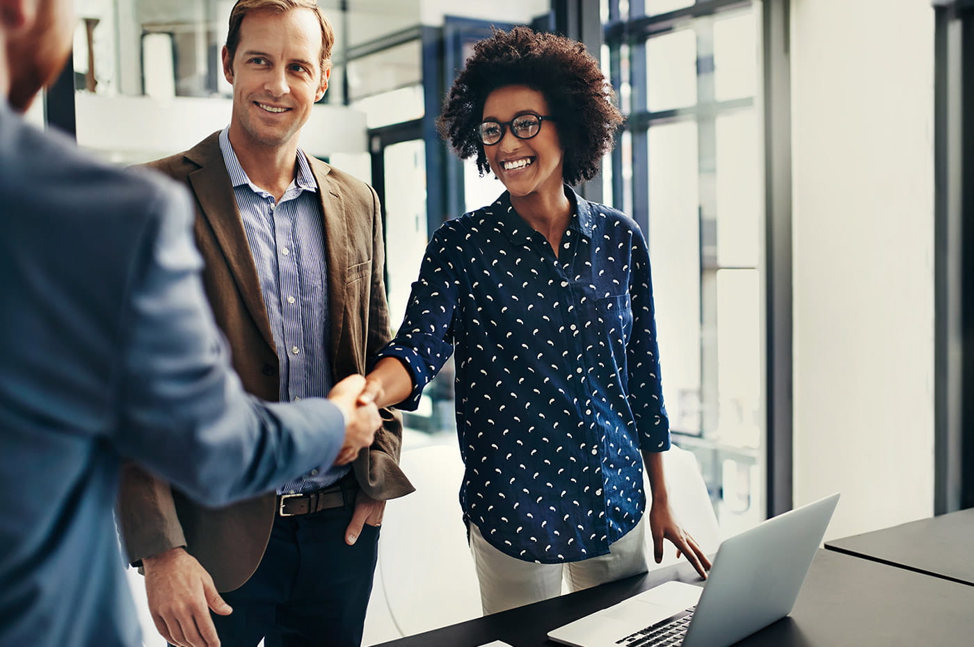 Man and woman shaking hands and smiling.