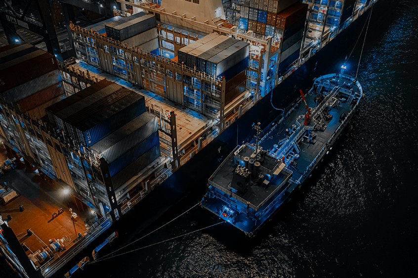 A shipping container docked at a shipyard.