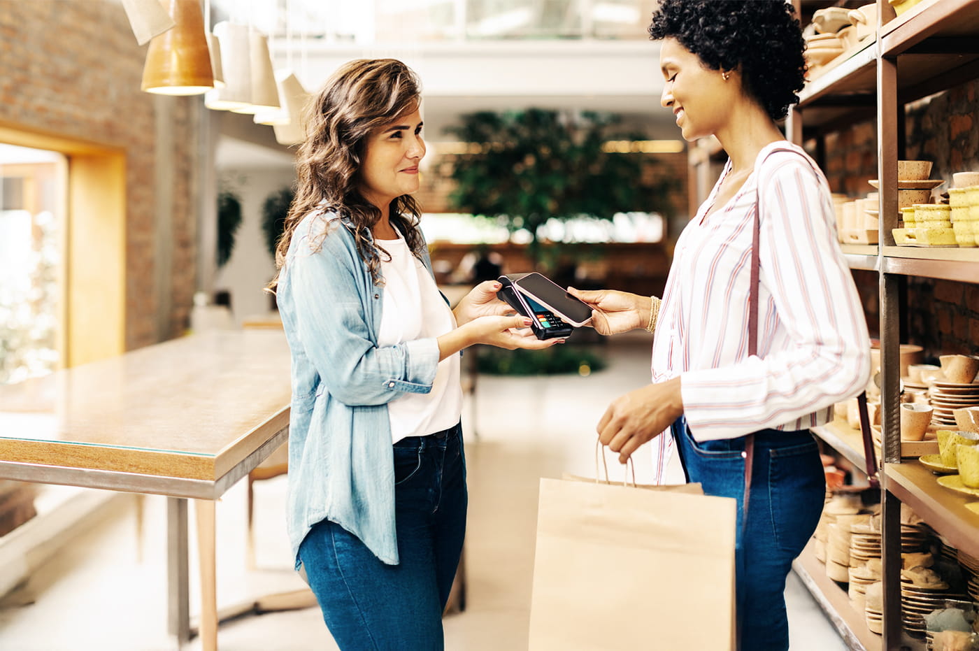 A woman using a phone to pay for her purchases.